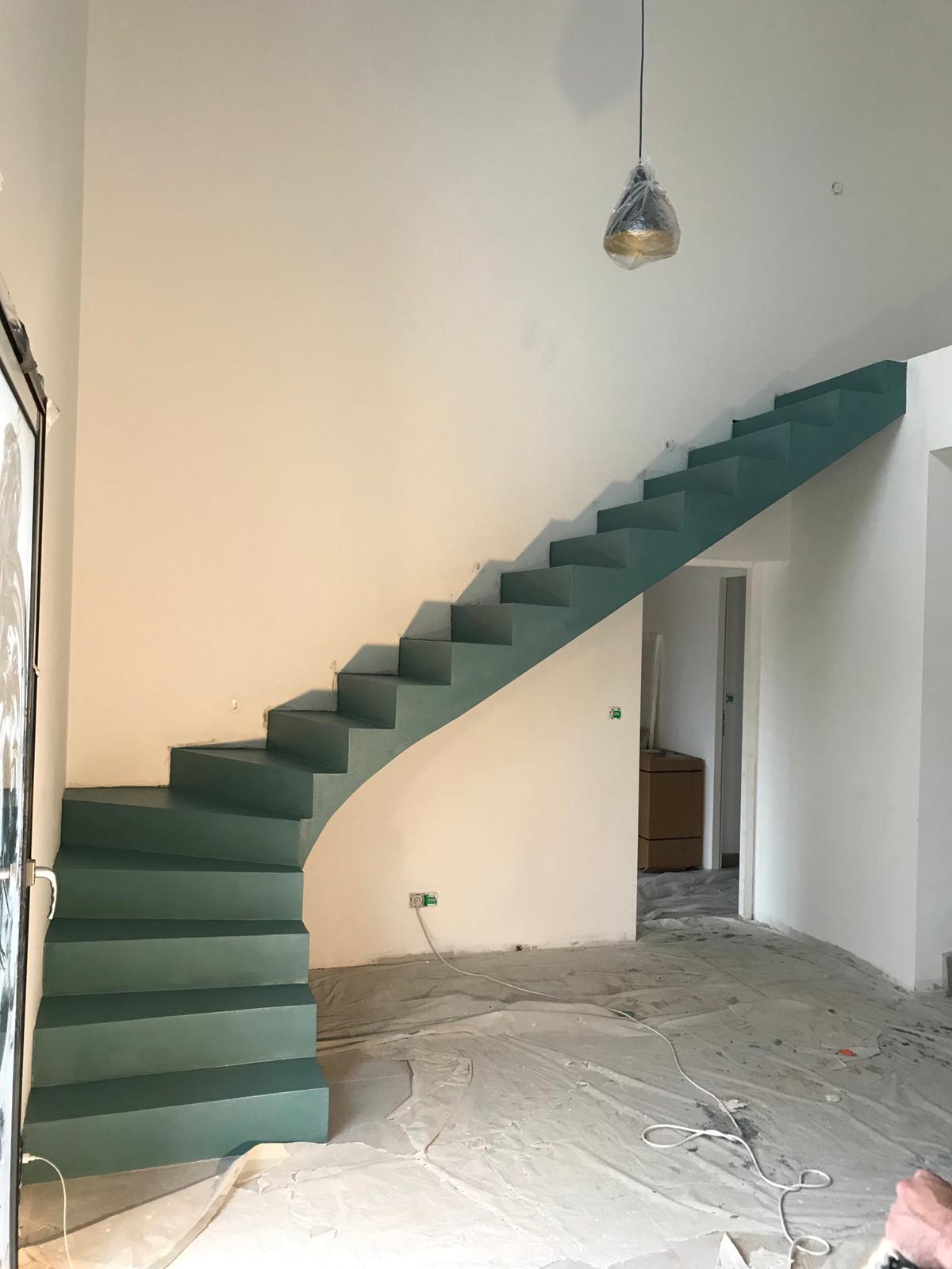 audacieux escalier crémaillère dans une pièce à vivre en béton ciré vernis mat couleur malachite pour un particulier
