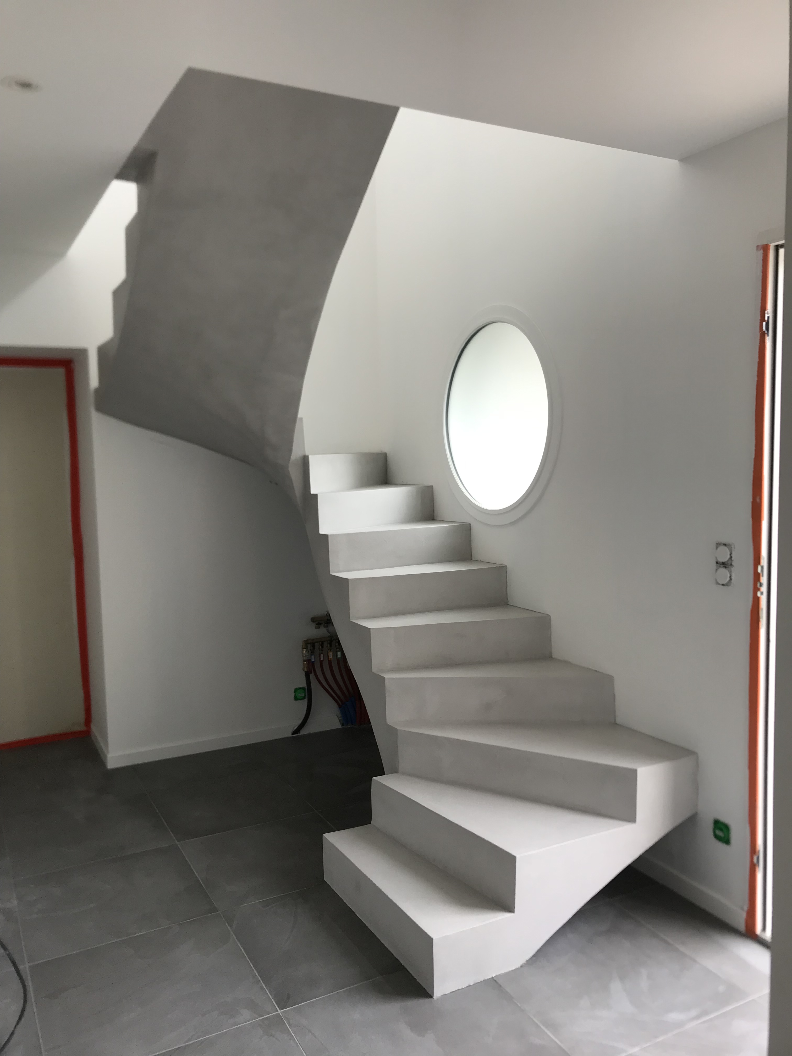 magnifique escalier à paillasse trois quart tournant en béton ciré couleur fossile à gujan-mestras pour un architecte