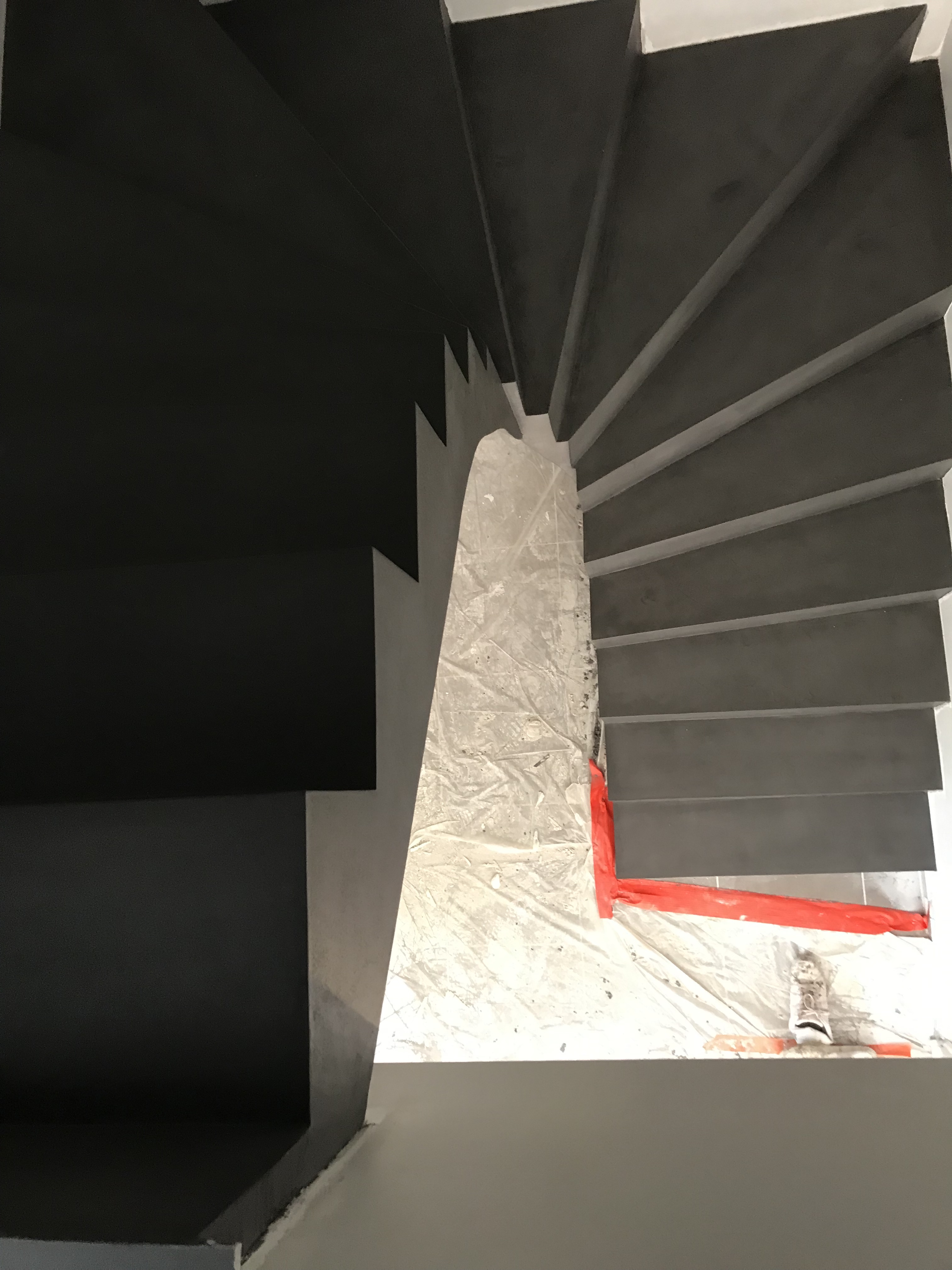 superbe escalier à paillasse deux quart tournant en béton ciré couleur gris orbital pour un constructeur