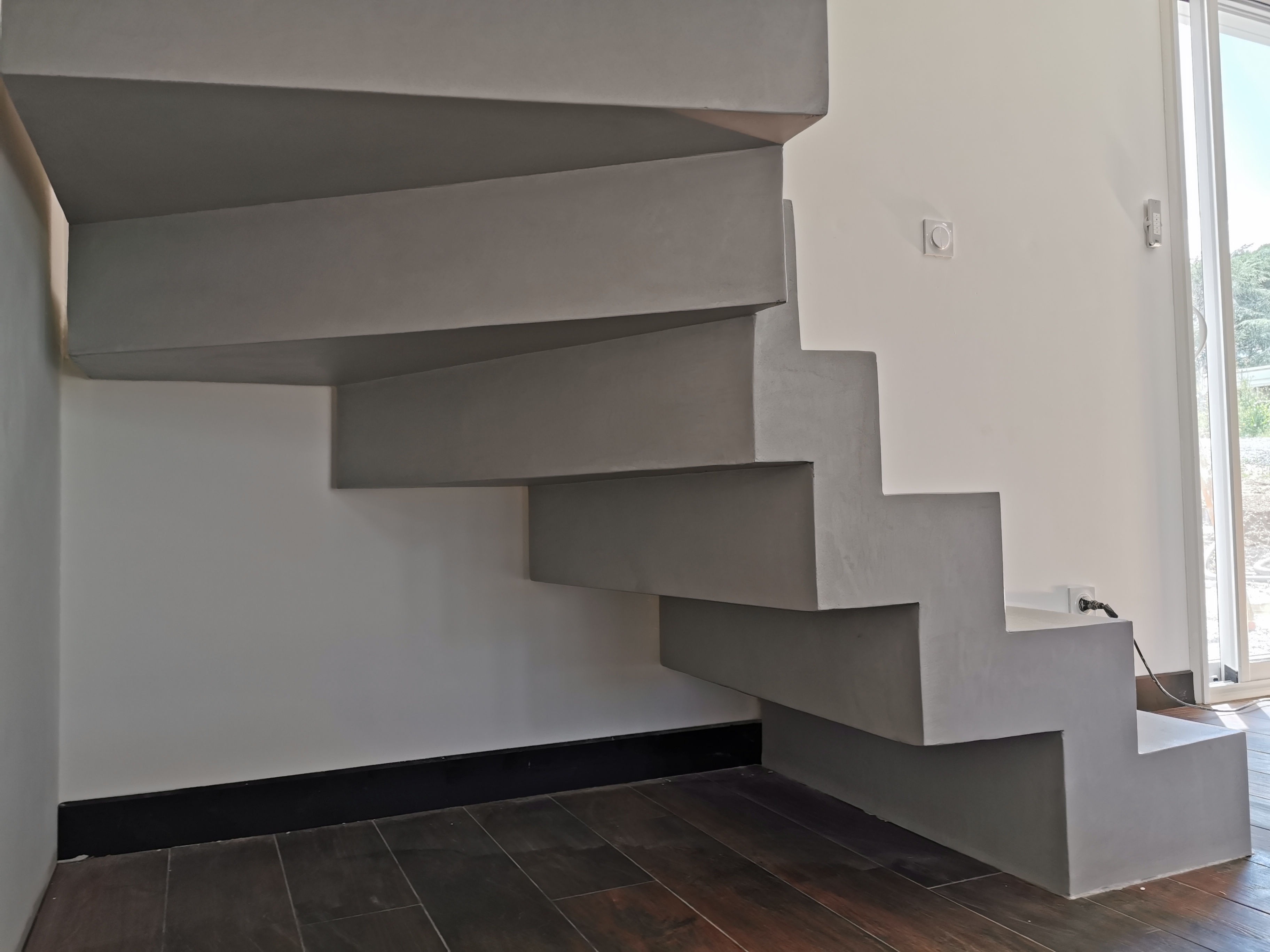 sublime escalier crémaillère décollé du mur en béton ciré vernis mat couleur gris souris À Quinsac près de bordeaux pour un constructeur