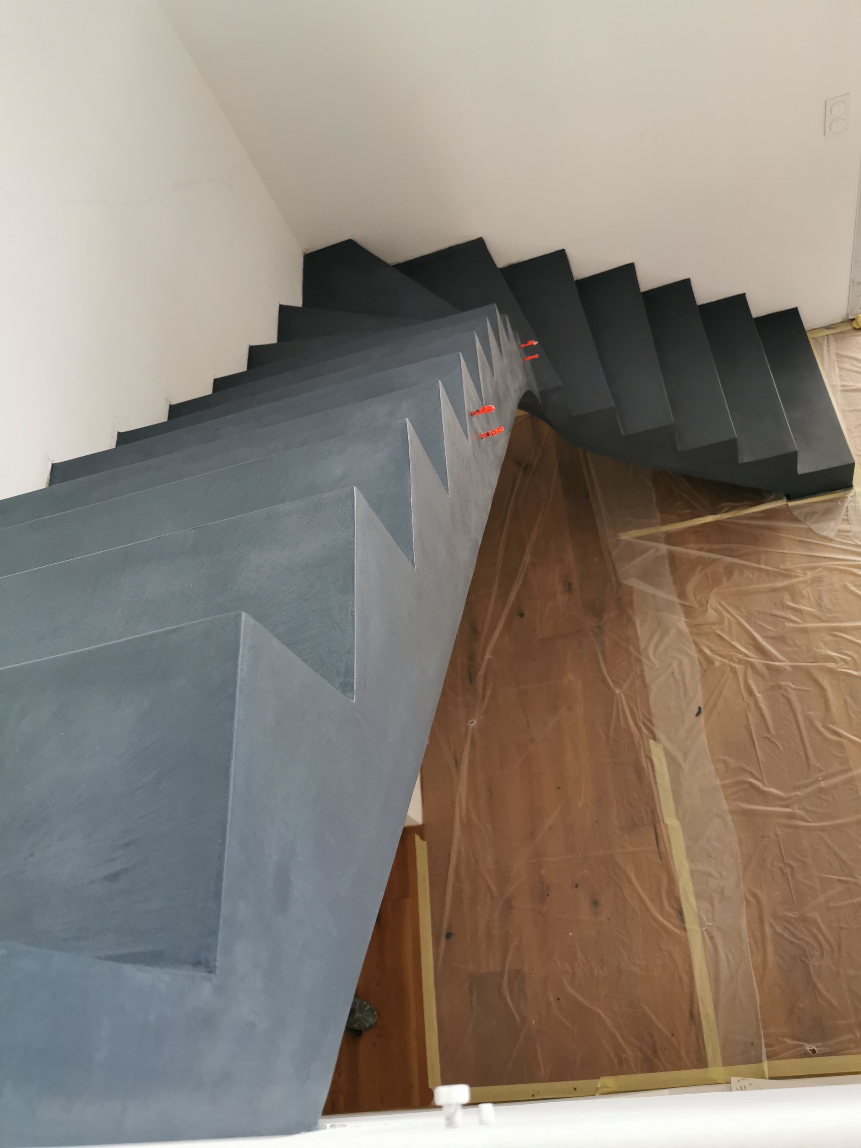 audacieux escalier à paillasse un quart tournant en béton ciré vernis mat couleur oxydium Au Taillan médoc proche de Bordeaux en Gironde pour un constructeur