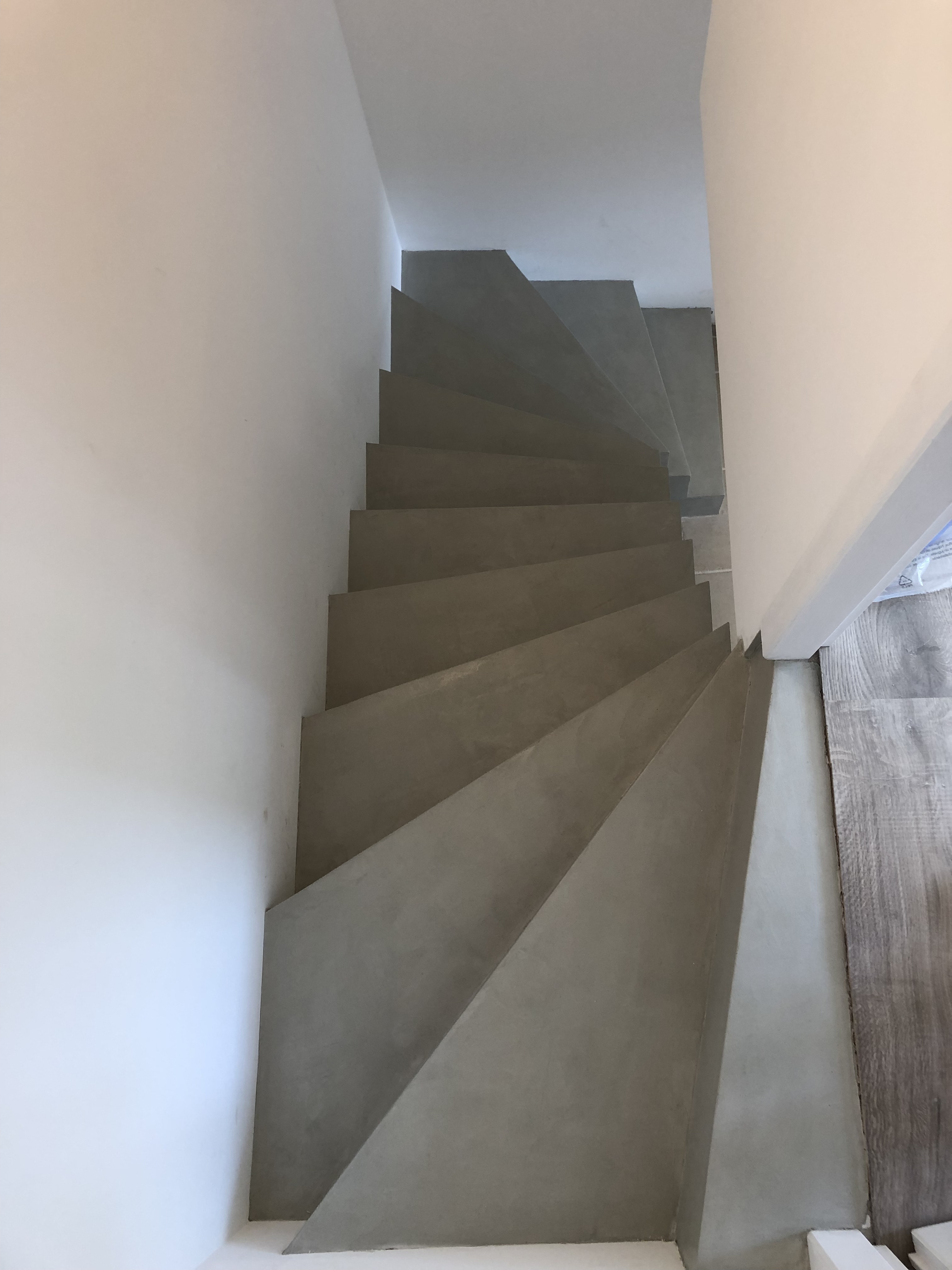 audacieux escalier à paillasse deux quart tournant en béton ciré vernis soyeux couleur gris perle à Royan en Charente maritime dans la région nouvelle aquitaine pour un particulier
