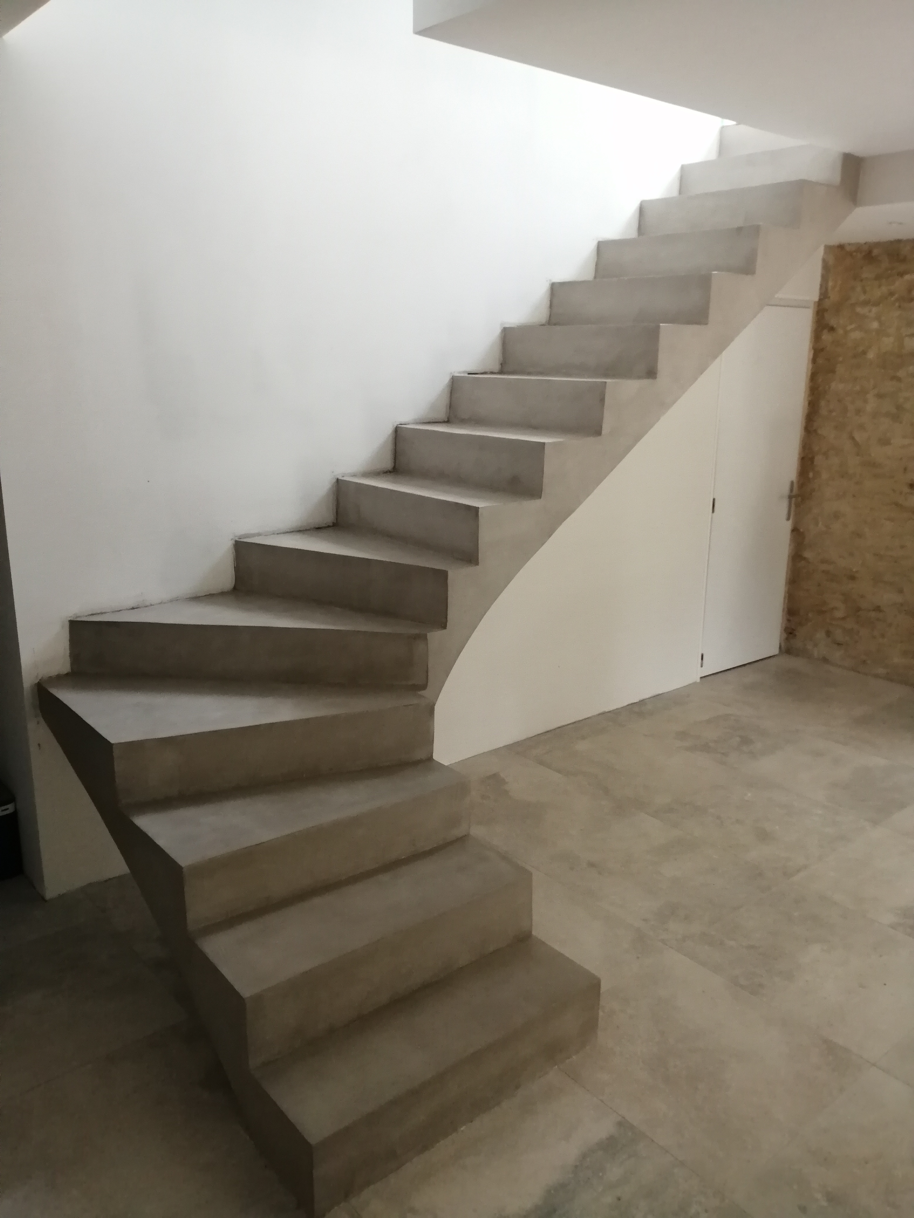elégant escalier à paillasse un quart balancé en béton ciré vernis mat couleur galet original à Nîmes dans le département du Gard (30000) en Languedoc pour un particulier