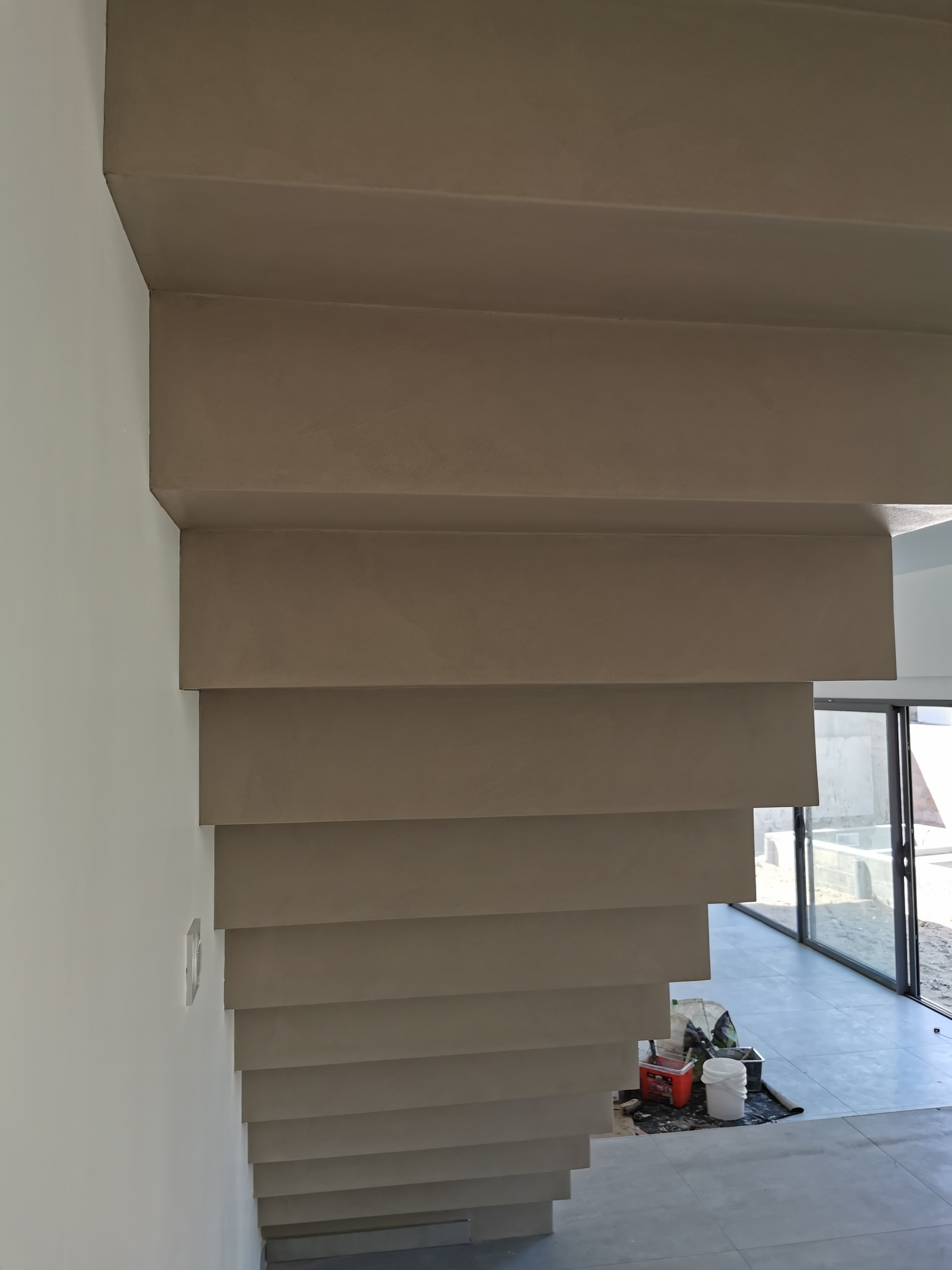 sublime escalier crémaillère dans une pièce à vivre en béton ciré vernis mat couleur galet original À arcachon proche Bordeaux pour un architecte