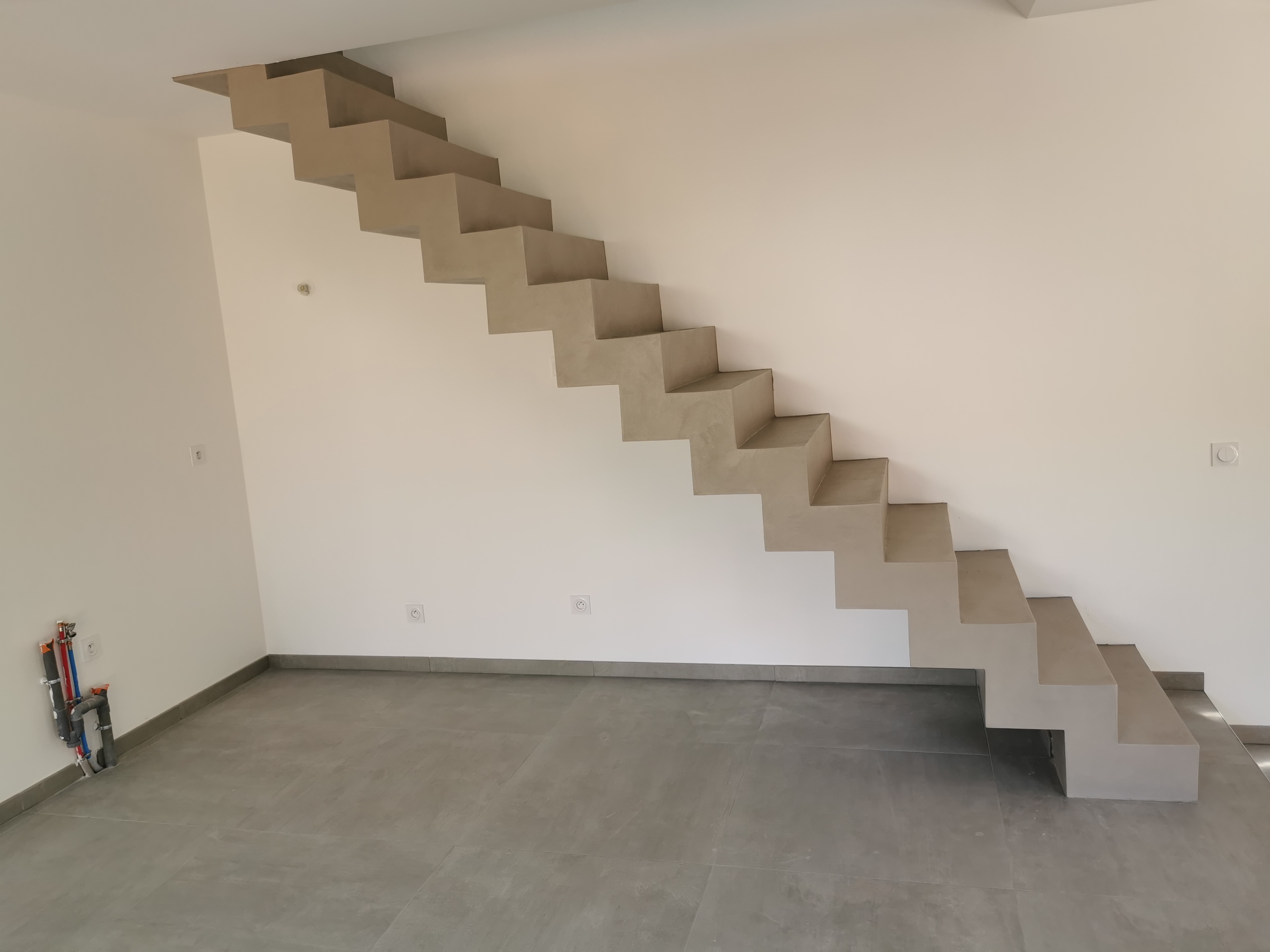 sublime escalier crémaillère dans une pièce à vivre en béton ciré vernis mat couleur galet original À arcachon proche Bordeaux pour un architecte