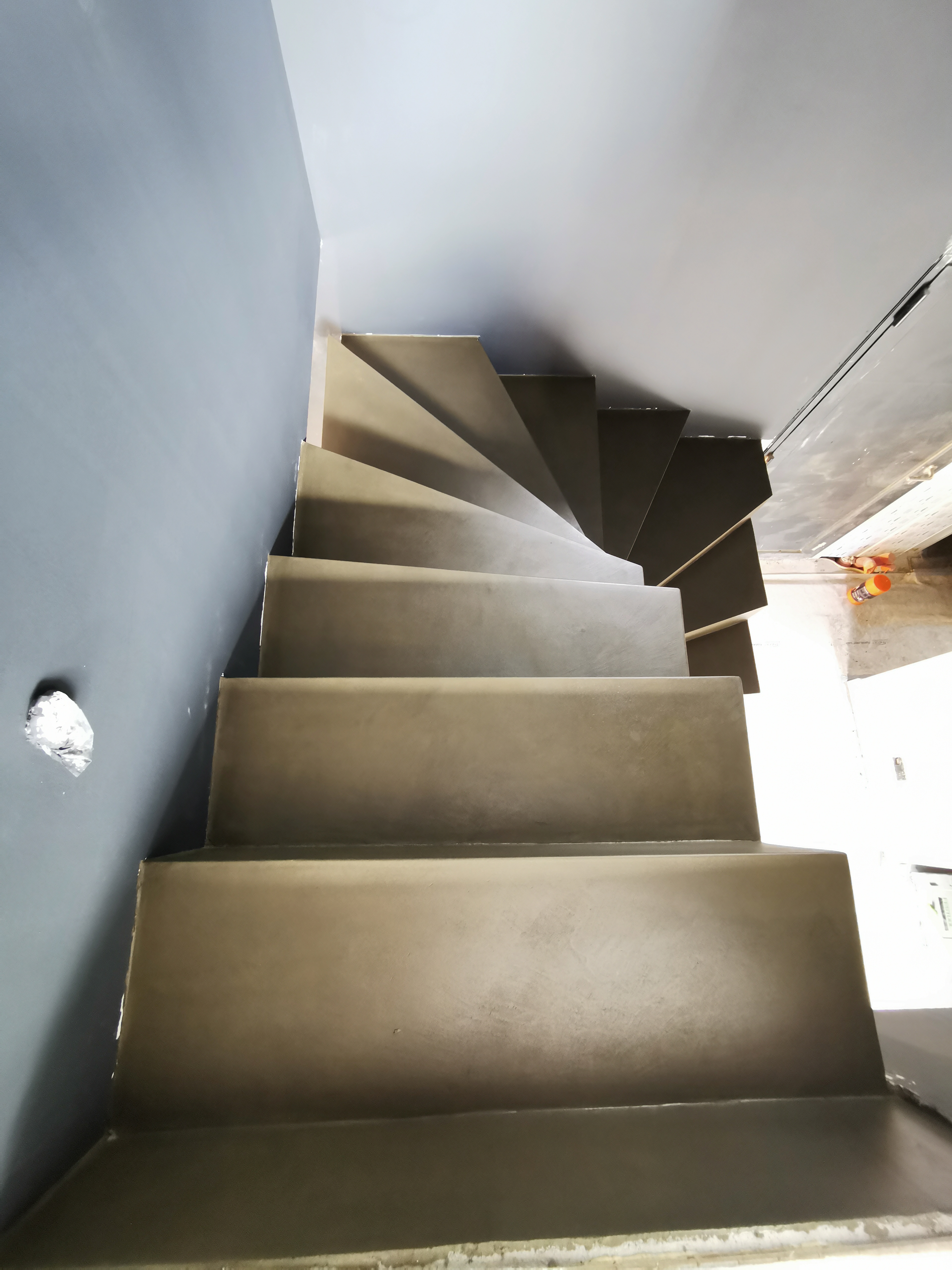 audacieux escalier crémaillère deux quart tournant en béton ciré vernis mat couleur gibraltar Au Pyla-Sur-Mer en Aquitaine dans le sud ouest de la France. pour un maitre d'œuvre