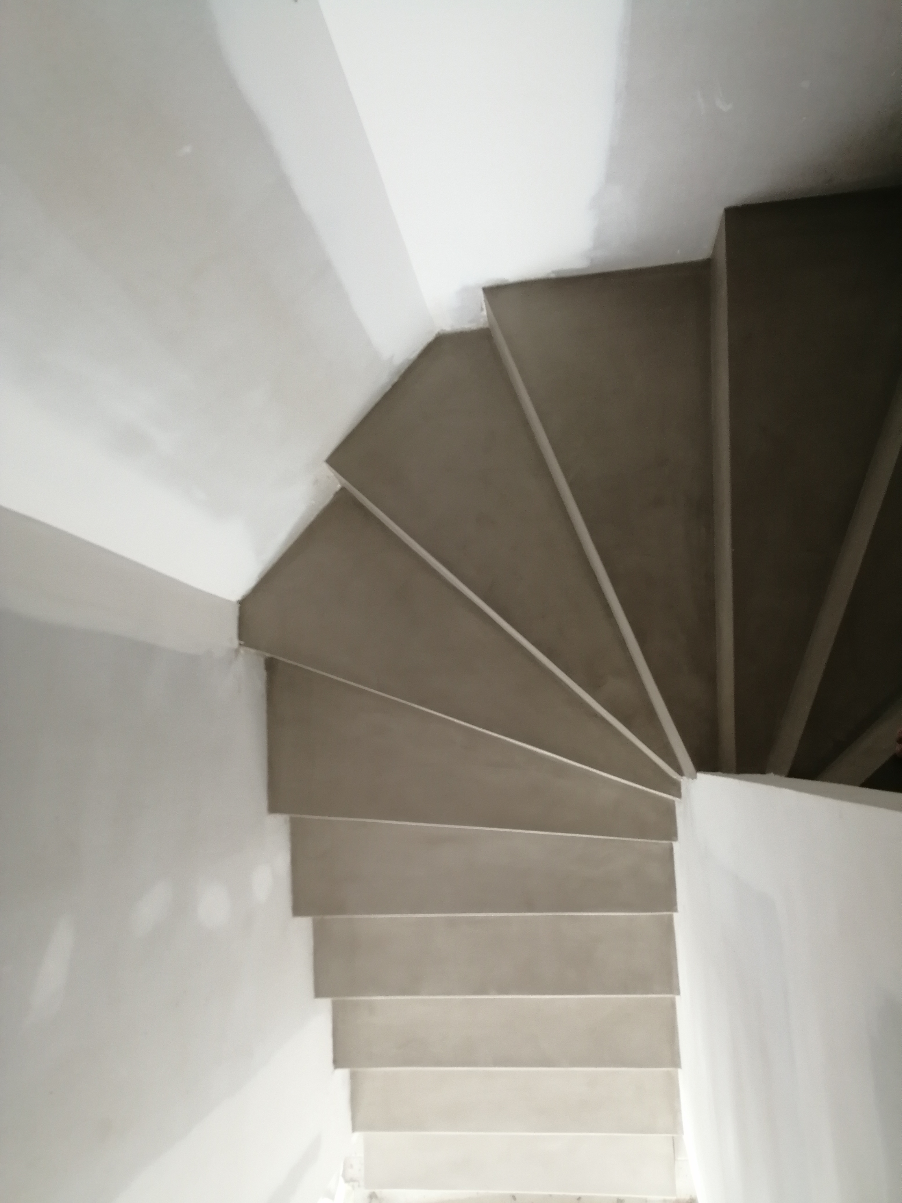 elégant escalier à paillasse deux quart tournant en béton ciré vernis soyeux couleur galet original à Clapier dans le département de l herault. pour un architecte