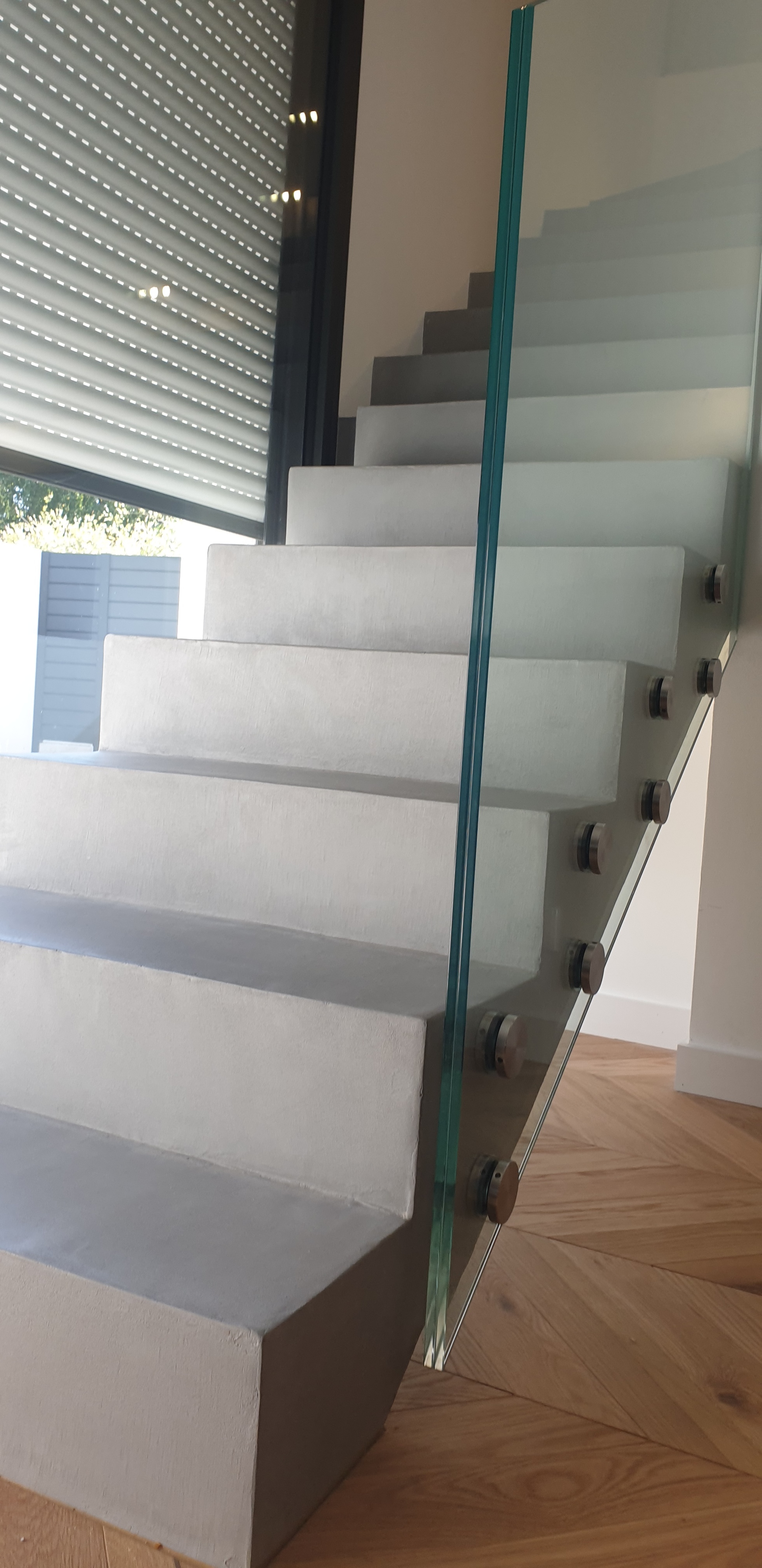 Garde corps en verre sur plots sur un escalier en béton ciré