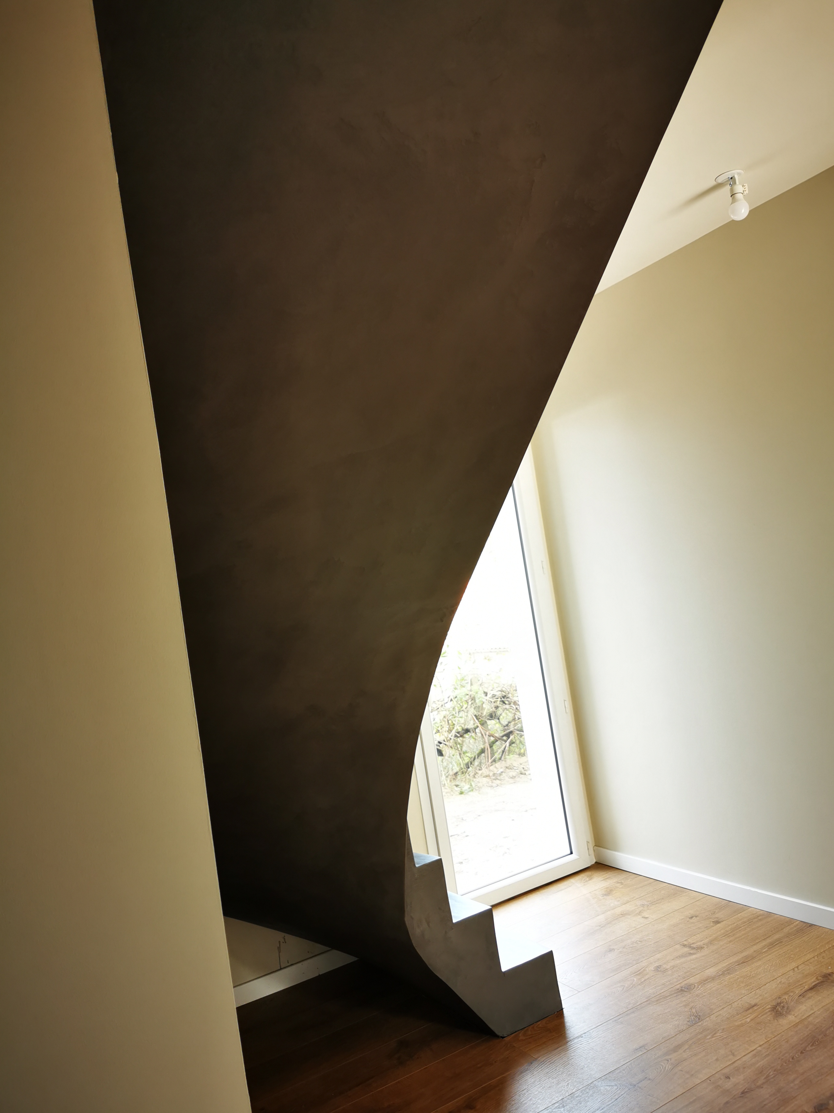 remarquable escalier à paillasse un quart tournant en béton ciré vernis mat couleur platinium à anglet au pays Basque en Nouvelle aquitaine pour un maitre d'œuvre