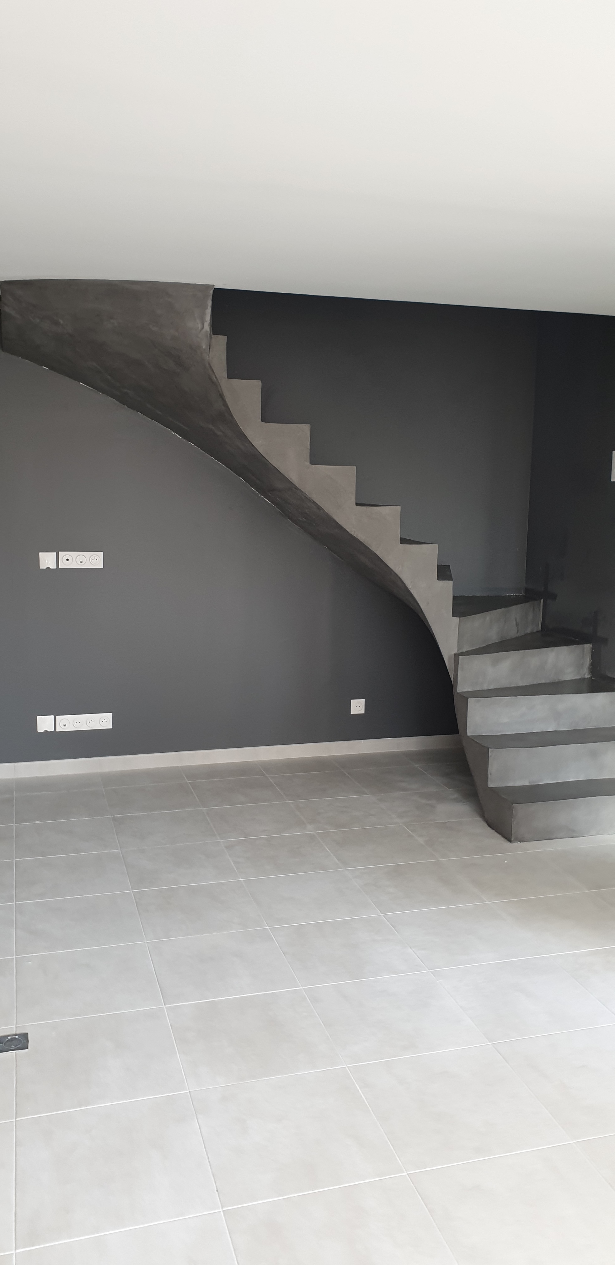 elégant escalier à paillasse d'un salon en béton ciré couleur gris aberdeen a St Nazaire pour un maitre d'œuvre Scal’in finition 44