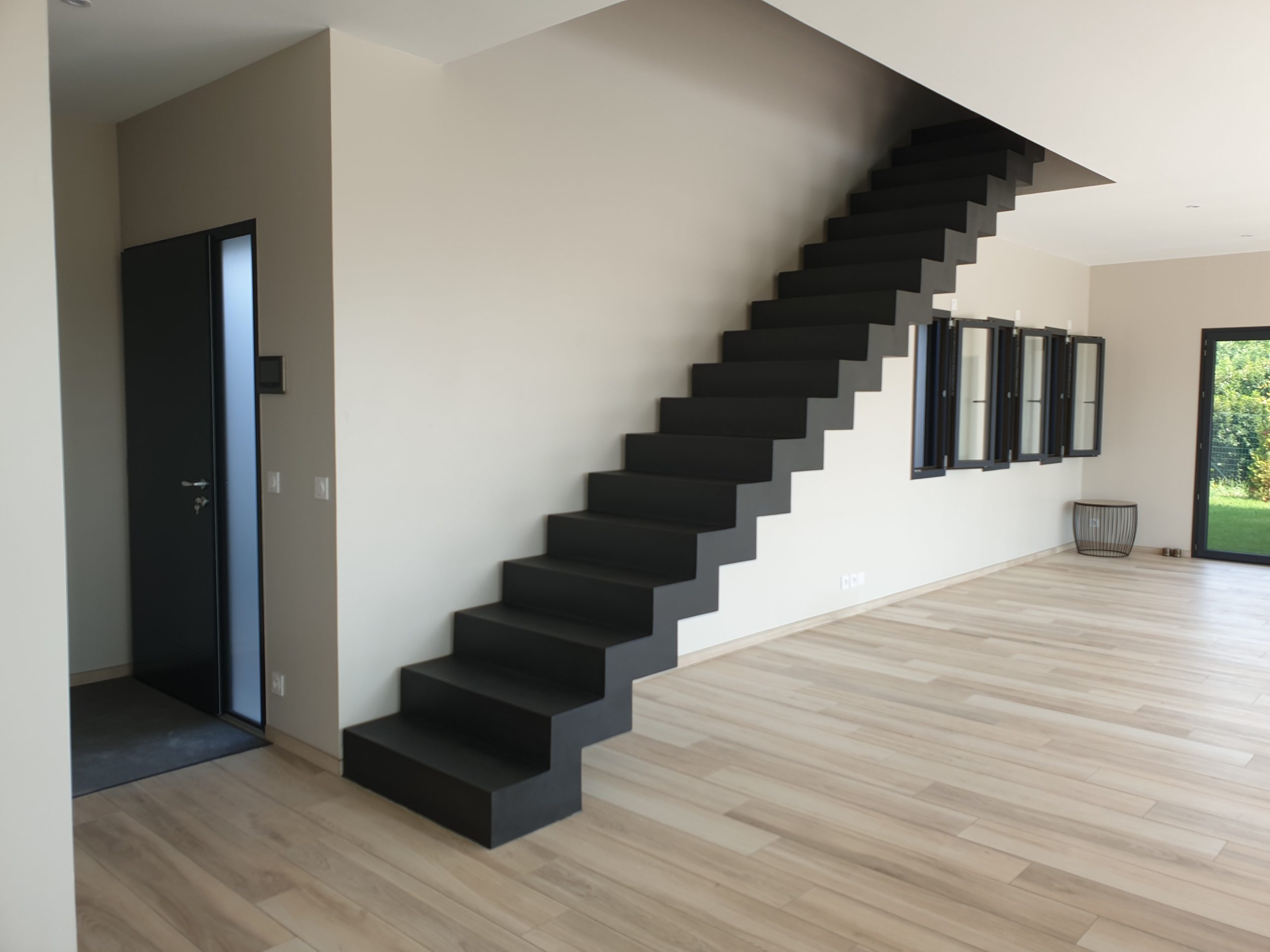 Béton ciré appliqué sur un escalier design placé à l'entrée d'une maison individuelle