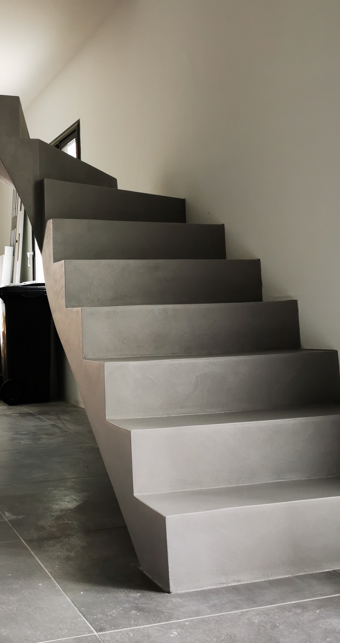Départ des marches de l'escalier décoré en béton ciré gris argent