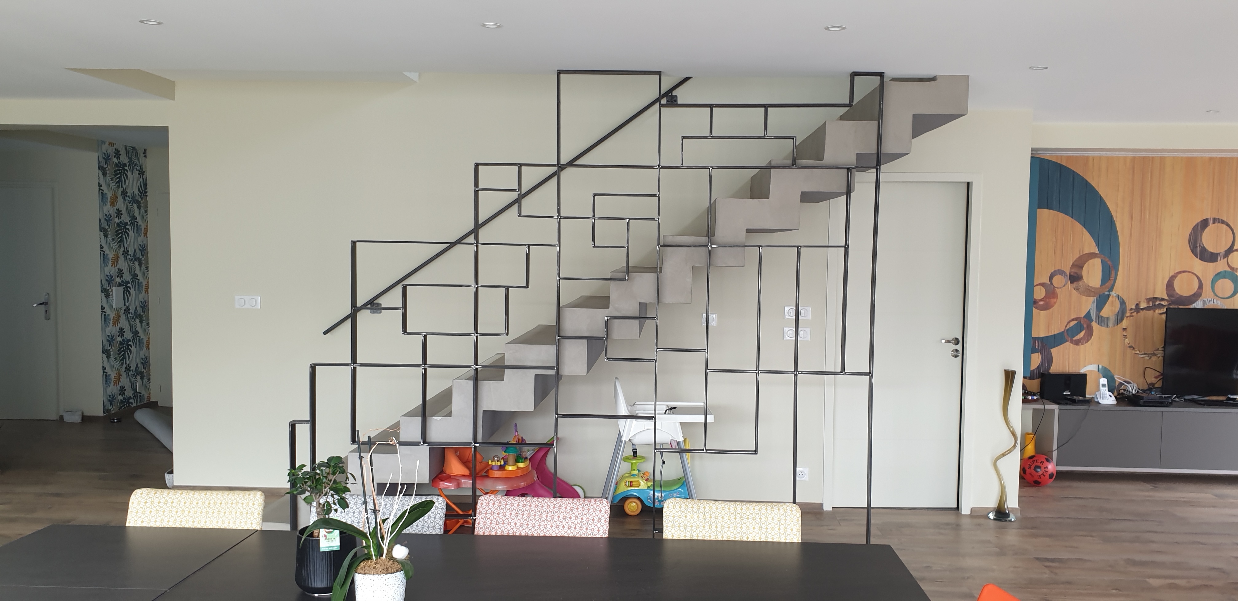 Béton ciré sur un escalier sur un fond de mur blanc composé d'un garde corps aux formes géométriques dans un salon