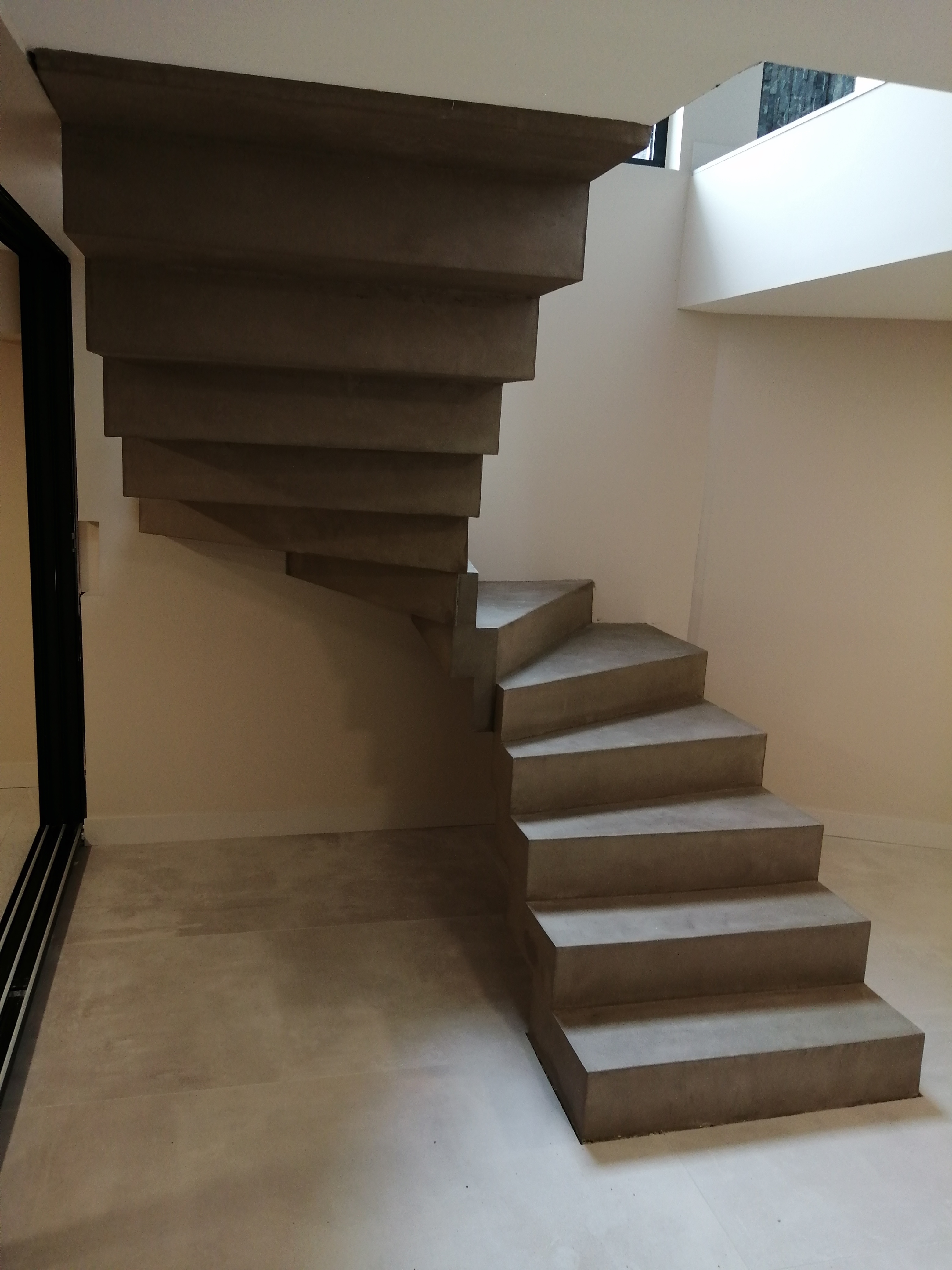 Revêtement en béton ciré couleur Persan sur cet escalier crémaillère balancé