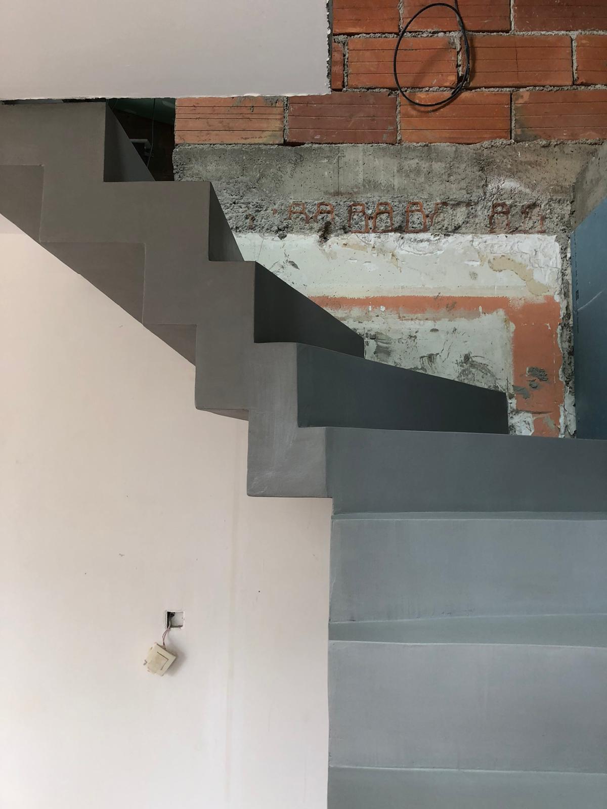 Application d'un béton ciré sur un escalier dans une maison en rénovation