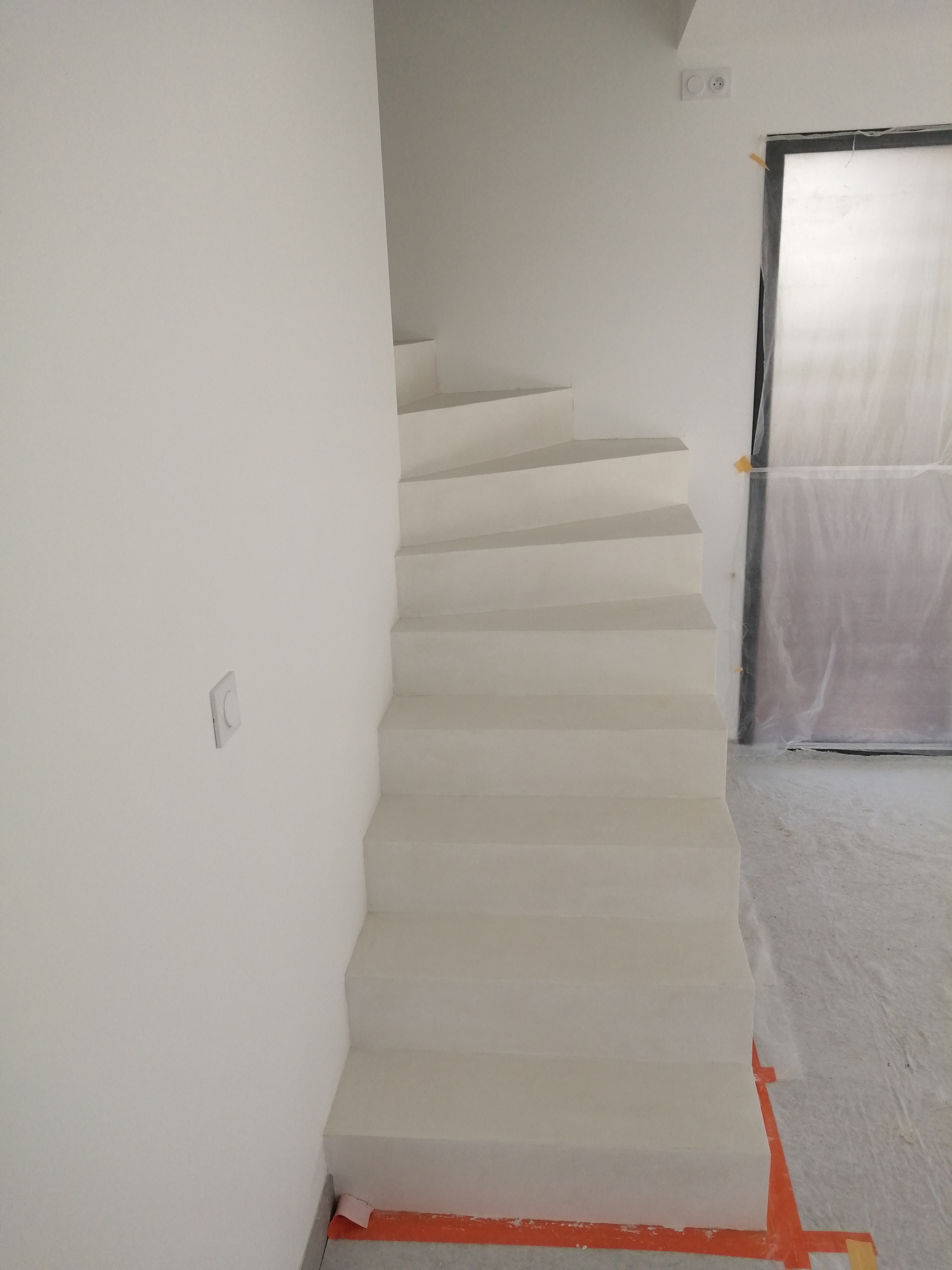 Béton ciré couleur blanc crème ou everest sur un escalier dans maison en construction