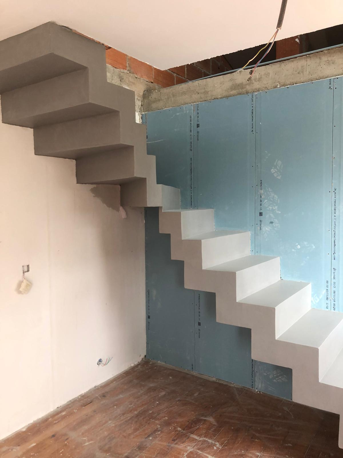 Béton ciré gris argent sur un escalier crémaillère un quart balancé dans une maison en cours de rénovation