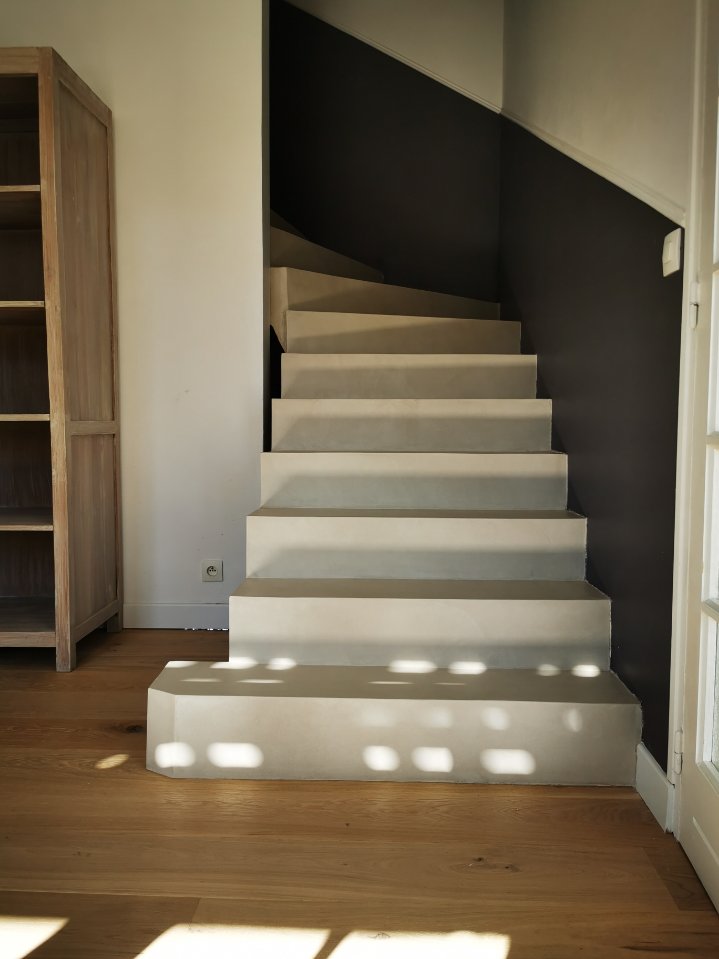 Finition béton ciré sur un escalier béton à paillasse dans une maison individuelle