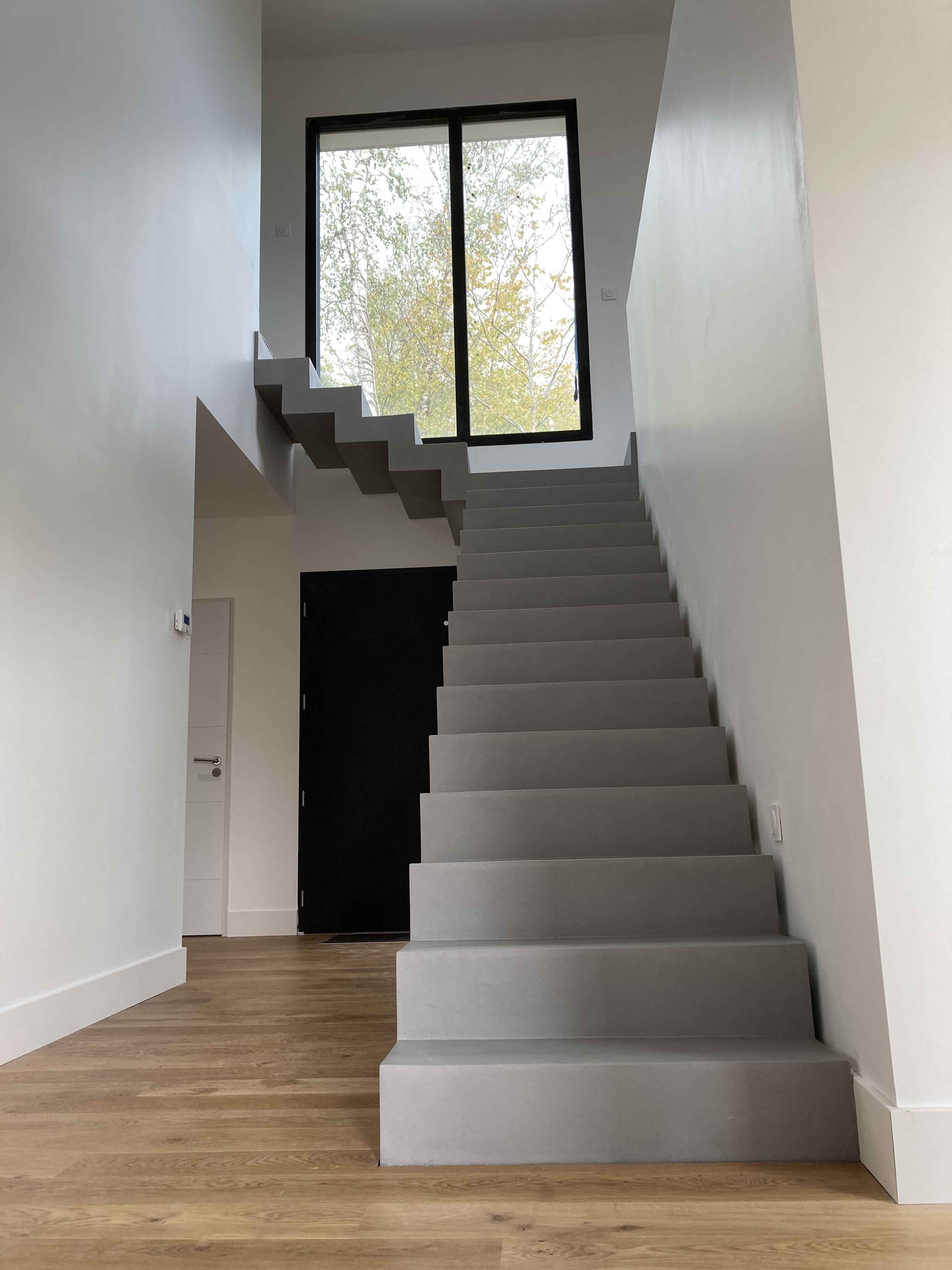 Béton ciré gris sur un escalier composé de volées droite et d'un palier intermédiaire