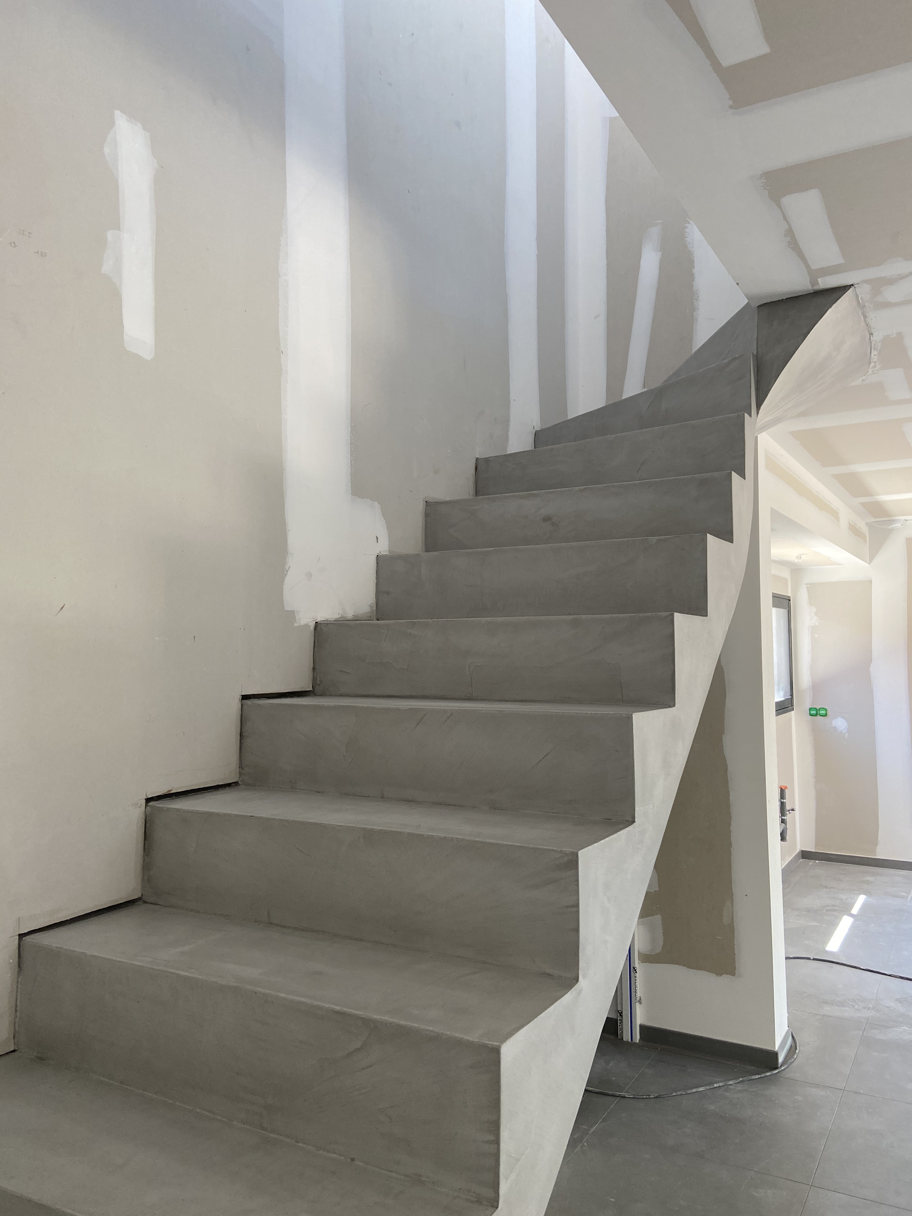 Escalier à paillasse en béton ciré, d'une maison individuelle entre Eperlecques et Arques. Matériau dur à l'usure, résistant aux rayures et autres chocs.