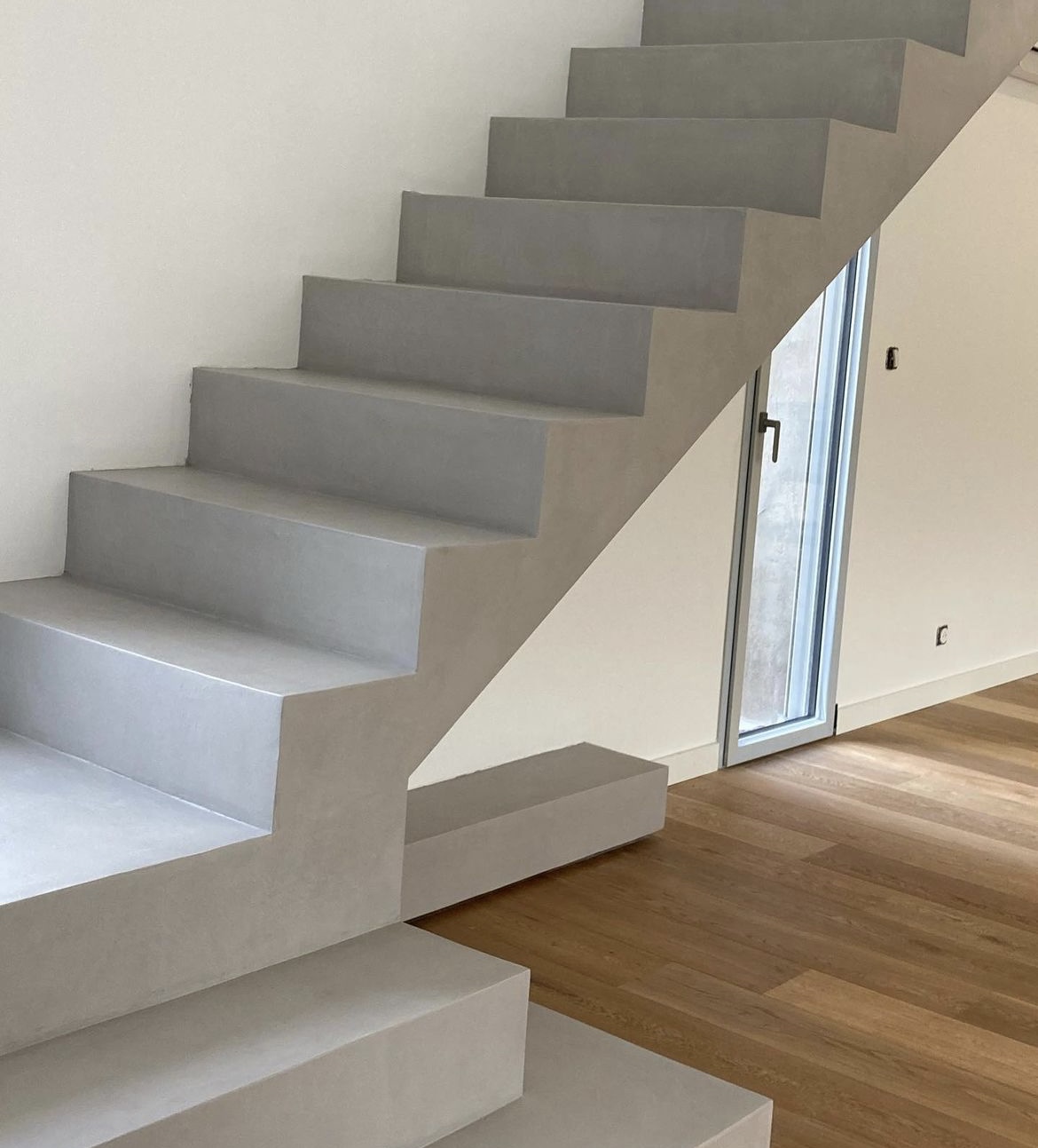 Escalier en béton ciré dans une maison individuelle, en Nouvelle-Aquitaine.